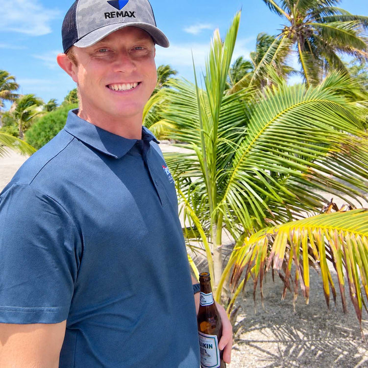 Clancy Sherwood showing clients a private island with a Belikin beer in hand